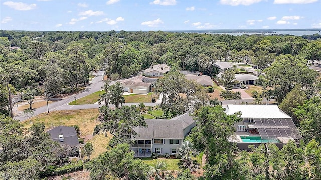 drone / aerial view featuring a residential view and a view of trees
