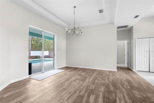 11344 Gallinule Ave, Weeki Wachee, FL 34613 - unfurnished dining area with visible vents, baseboards, wood finished floors, and a notable chandelier