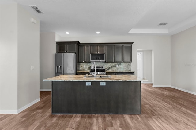 11344 Gallinule Ave, Weeki Wachee, FL 34613 - kitchen featuring baseboards, appliances with stainless steel finishes, an island with sink, and a sink