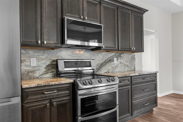 11344 Gallinule Ave, Weeki Wachee, FL 34613 - kitchen with baseboards, decorative backsplash, wood finished floors, and stainless steel appliances