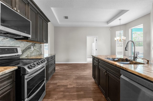 11344 Gallinule Ave, Weeki Wachee, FL 34613 - kitchen featuring visible vents, appliances with stainless steel finishes, a sink, a raised ceiling, and dark wood-style floors