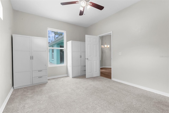 11344 Gallinule Ave, Weeki Wachee, FL 34613 - unfurnished bedroom with baseboards, light carpet, and ceiling fan with notable chandelier