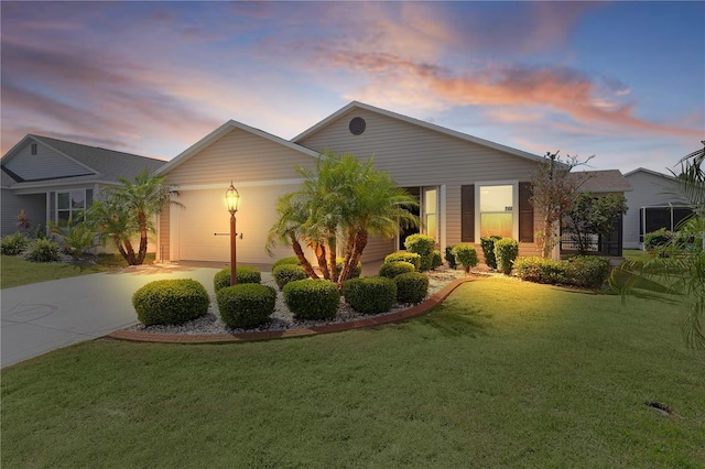 ranch-style home with an attached garage, concrete driveway, and a front lawn
