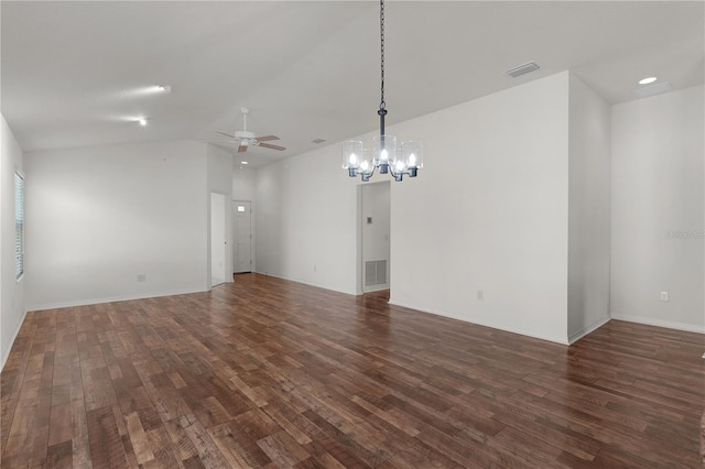 empty room with visible vents, ceiling fan with notable chandelier, dark wood finished floors, and lofted ceiling