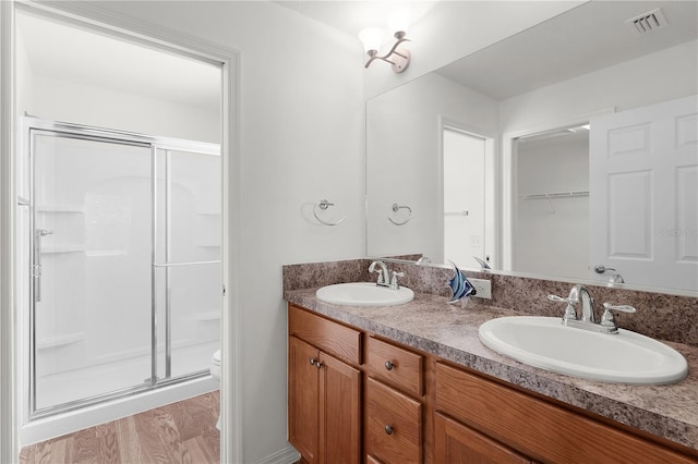full bathroom featuring visible vents, a sink, and a shower stall