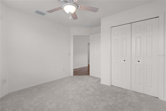 unfurnished bedroom featuring a ceiling fan, visible vents, carpet floors, baseboards, and a closet