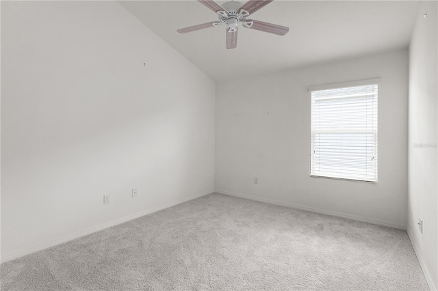 carpeted spare room featuring baseboards, a ceiling fan, and lofted ceiling