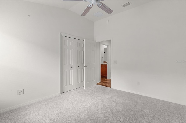 unfurnished bedroom featuring visible vents, carpet floors, a closet, baseboards, and vaulted ceiling