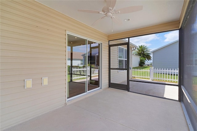unfurnished sunroom featuring a ceiling fan and a healthy amount of sunlight