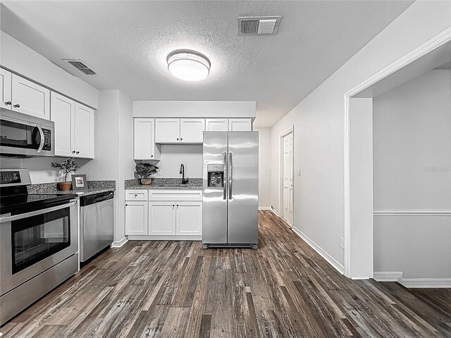 kitchen with dark wood-style flooring, appliances with stainless steel finishes, and visible vents