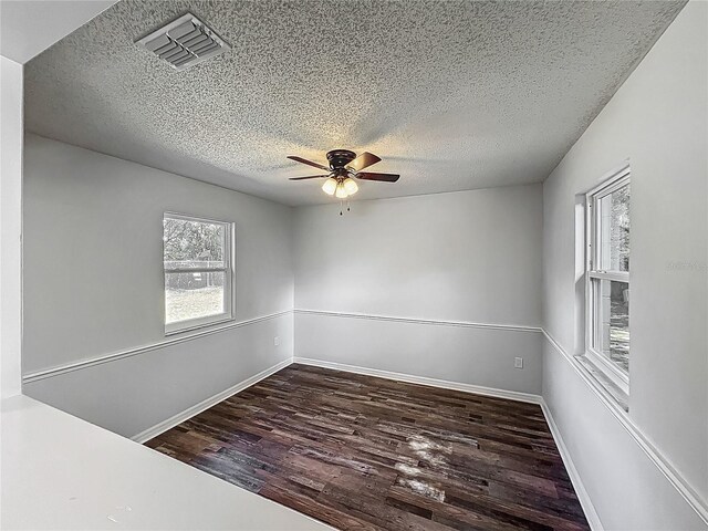 unfurnished room featuring visible vents, a ceiling fan, a textured ceiling, and wood finished floors