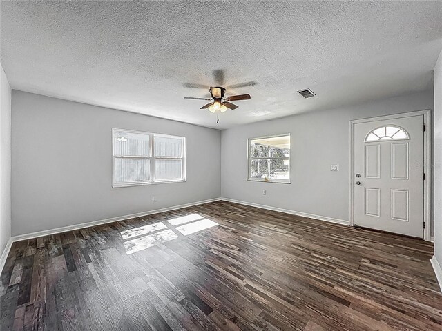 foyer entrance with visible vents, dark wood-style flooring, baseboards, a textured ceiling, and a ceiling fan