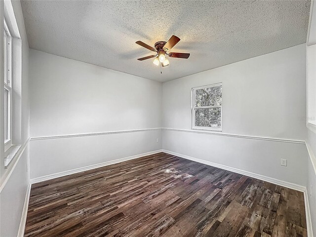 empty room with a ceiling fan, dark wood-style flooring, and a textured ceiling