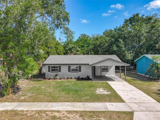 single story home with concrete driveway, a front lawn, and an attached carport