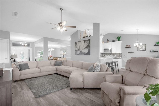 36700 Oconee Ave, Eustis, FL 32736 - living area featuring visible vents, ceiling fan with notable chandelier, lofted ceiling, and light wood-type flooring