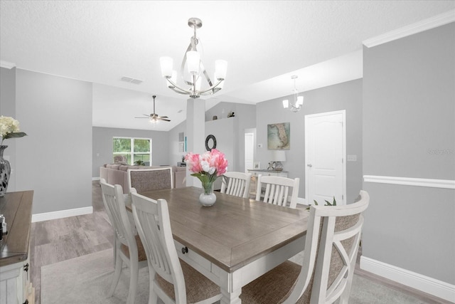 36700 Oconee Ave, Eustis, FL 32736 - dining area with baseboards, ceiling fan with notable chandelier, lofted ceiling, and light wood-type flooring