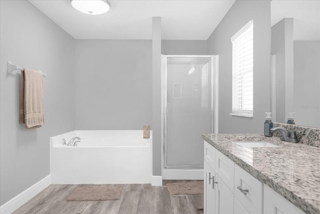 36700 Oconee Ave, Eustis, FL 32736 - full bath with vanity, baseboards, wood finished floors, a garden tub, and a stall shower