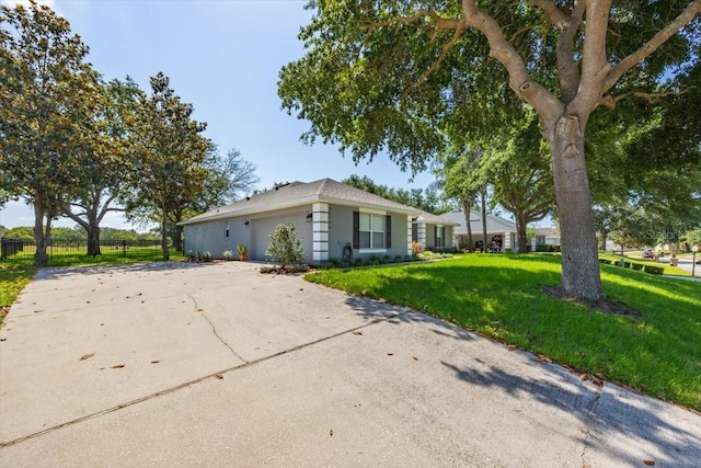 36700 Oconee Ave, Eustis, FL 32736 - view of side of property with fence, a garage, stucco siding, a lawn, and driveway