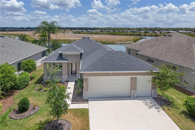 ranch-style home featuring roof with shingles, an attached garage, stone siding, stucco siding, and concrete driveway