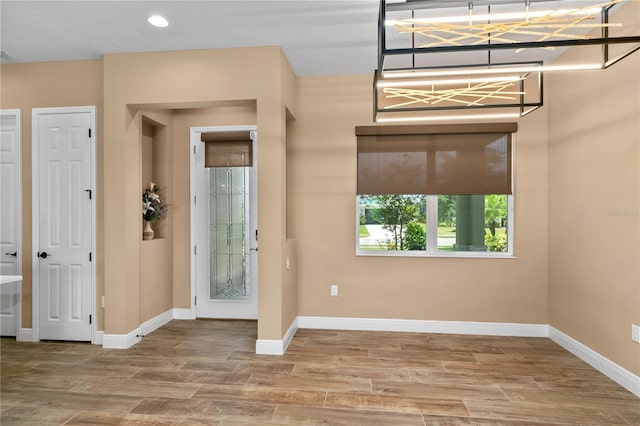 foyer entrance with recessed lighting, baseboards, and wood finished floors