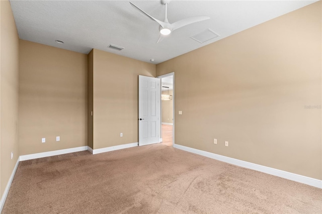 spare room with baseboards, visible vents, ceiling fan, and carpet