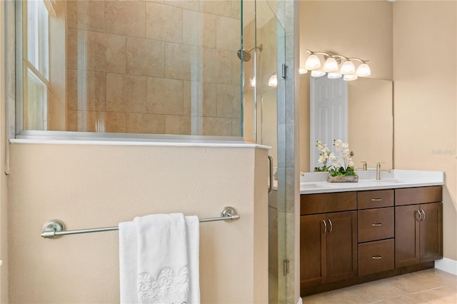 full bathroom featuring double vanity, tile patterned flooring, a shower stall, and a sink