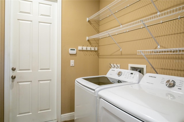 washroom featuring washing machine and dryer, baseboards, and laundry area