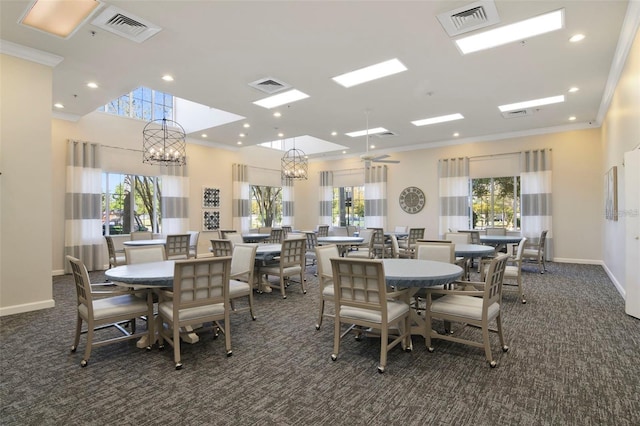 dining area with ornamental molding, dark colored carpet, and visible vents