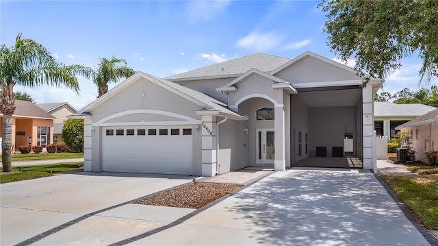 view of front of property featuring driveway, stucco siding, french doors, and a garage