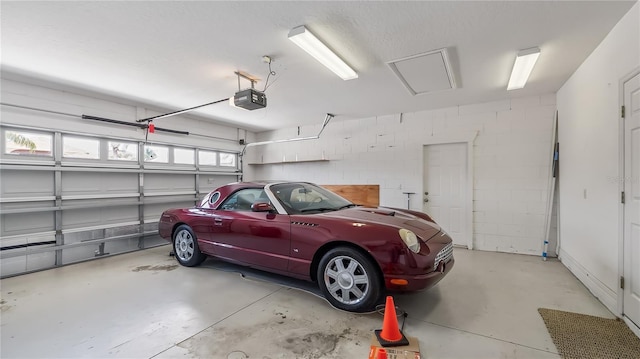 garage featuring concrete block wall and a garage door opener