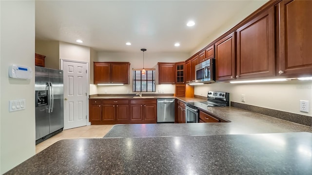 kitchen featuring recessed lighting, decorative light fixtures, a sink, dark countertops, and appliances with stainless steel finishes