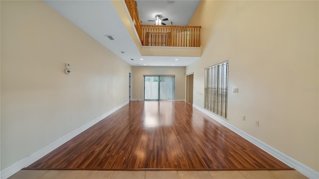 unfurnished living room with baseboards, visible vents, and wood finished floors