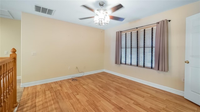 spare room with light wood-style floors, visible vents, baseboards, and a ceiling fan