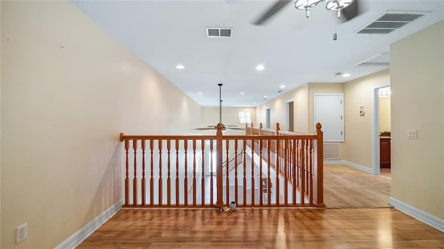 hall featuring visible vents, wood finished floors, baseboards, and recessed lighting