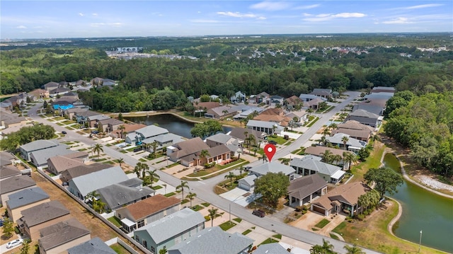 aerial view with a water view, a view of trees, and a residential view