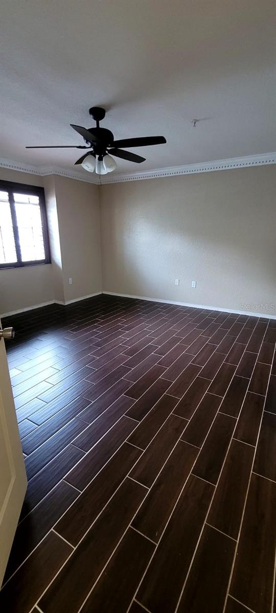 14049 Fairway Island Dr Unit 118, Orlando, FL 32837 - spare room with baseboards, ceiling fan, and dark wood-type flooring