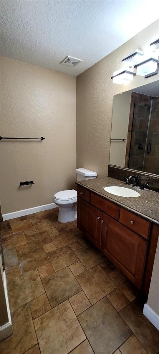 14049 Fairway Island Dr Unit 118, Orlando, FL 32837 - bathroom with visible vents, vanity, a textured wall, a textured ceiling, and a tile shower