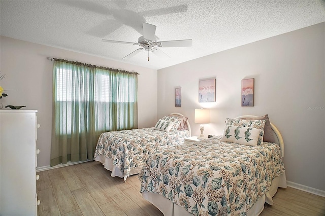 1318 Guerra Ave, The Villages, FL 32159 - bedroom with baseboards, a textured ceiling, ceiling fan, and wood finished floors