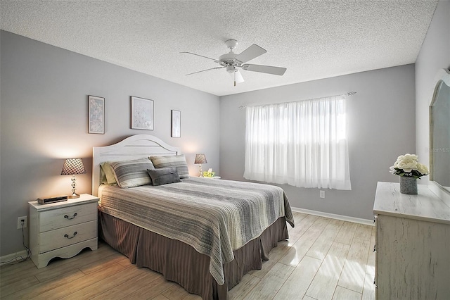1318 Guerra Ave, The Villages, FL 32159 - bedroom with baseboards, ceiling fan, a textured ceiling, and light wood-style flooring