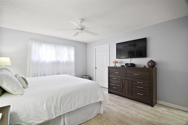 1318 Guerra Ave, The Villages, FL 32159 - bedroom featuring a ceiling fan, a textured ceiling, baseboards, and light wood-style floors