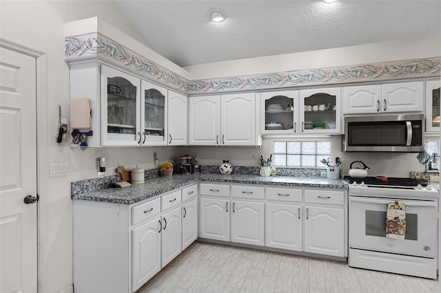 5500 Laver St, Leesburg, FL 34748 - kitchen featuring white cabinets, stainless steel microwave, glass insert cabinets, and white electric range