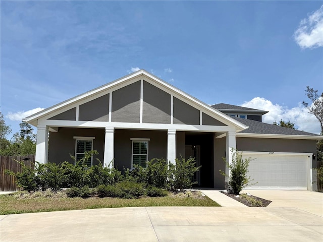 31857 Dahlia Ct, Eustis, FL 32736 - view of front of home featuring stucco siding, an attached garage, fence, driveway, and a porch