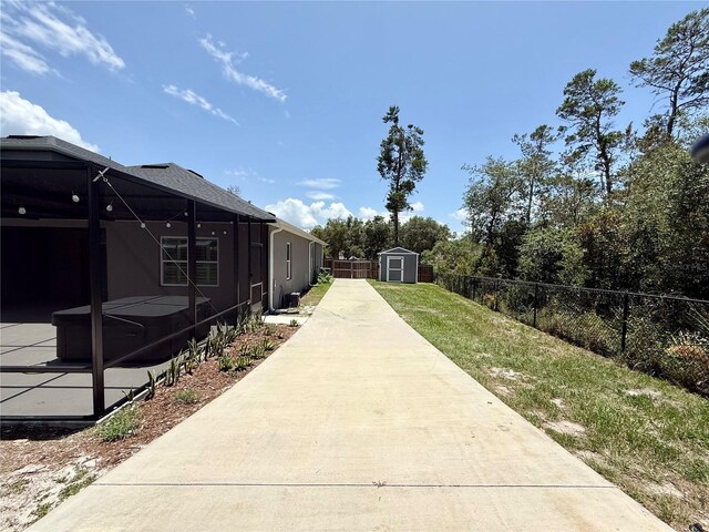 31857 Dahlia Ct, Eustis, FL 32736 - view of yard featuring a storage unit, a patio, glass enclosure, and a covered hot tub