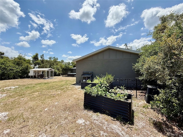 31857 Dahlia Ct, Eustis, FL 32736 - view of property exterior featuring a vegetable garden, board and batten siding, and a yard
