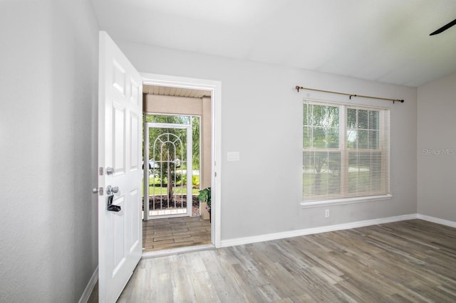 entrance foyer with baseboards, ceiling fan, and wood finished floors
