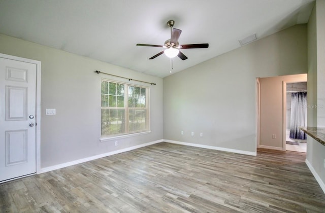 spare room with baseboards, a ceiling fan, lofted ceiling, and wood finished floors