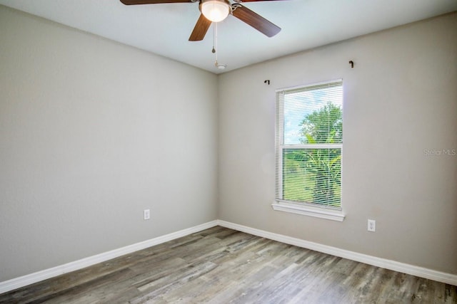 unfurnished room with baseboards, ceiling fan, and wood finished floors