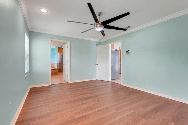 8709 Augusta Ct, Clermont, FL 34711 - unfurnished bedroom with baseboards, ornamental molding, freestanding refrigerator, and wood finished floors