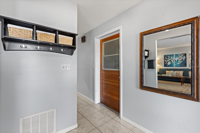 corridor featuring light tile patterned floors and baseboards