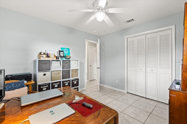 home office with light tile patterned floors, baseboards, ceiling fan, and visible vents